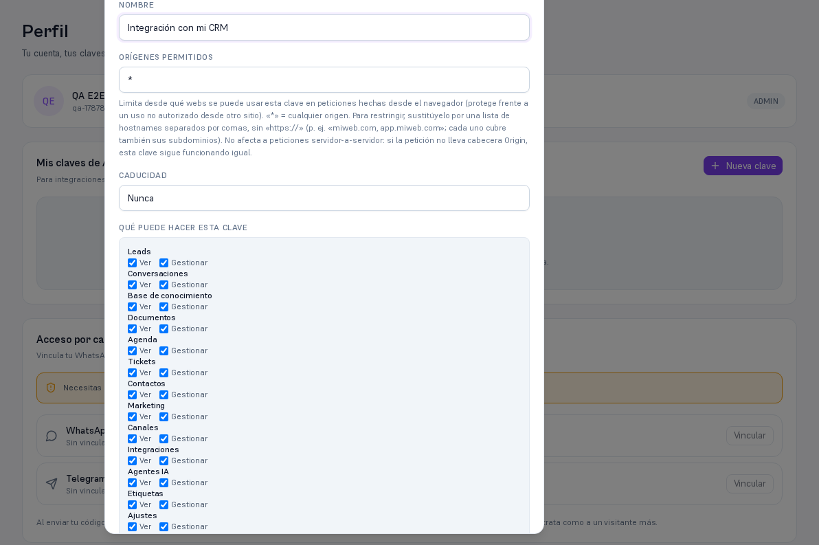 Modal Nueva clave de API con «Qué puede hacer esta clave» desplegado: una fila por área (Leads, Conversaciones, Base de conocimiento, Documentos, Agenda, Tickets, Contactos, Marketing, Canales, Integraciones, Agentes IA, Etiquetas, Ajustes, Facturación, Equipo, Seguridad…) con casillas Ver y Gestionar, todas marcadas